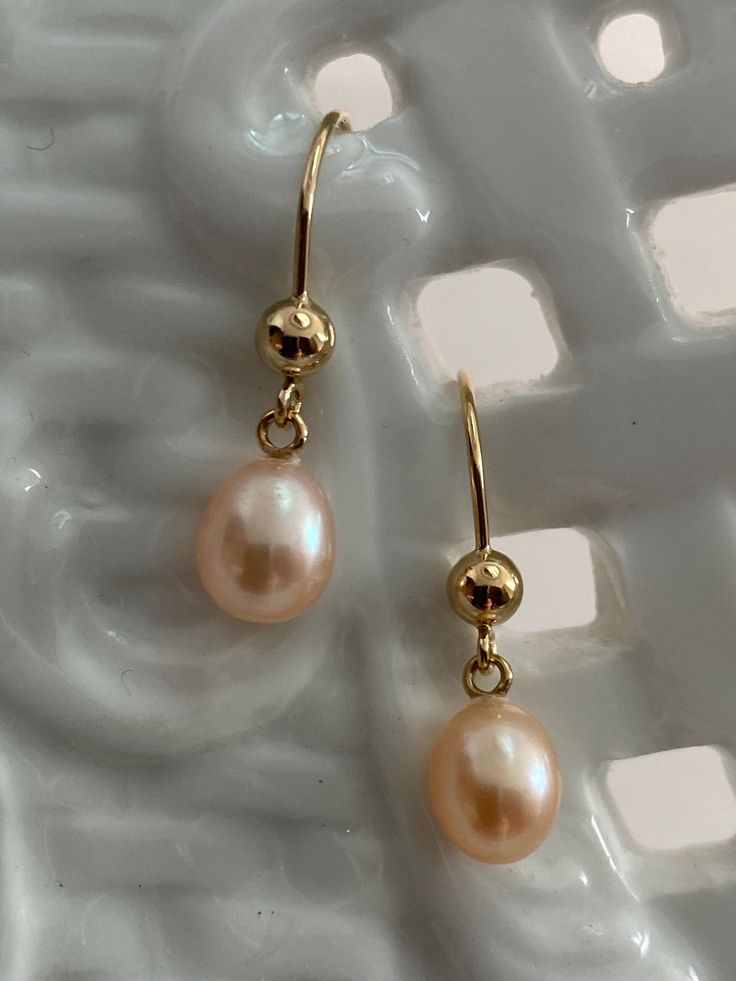 Stunning High-Luster beautiful plump pearls. Freshwater Akoya Teardrop Pearl Earrings, adorned with gorgeous nacre. These high-quality pearls, produced in the 1950s, are sure to captivate your attention.  Grown in freshwater estuaries in Australia, these pearls are cultivated in the same oysters (Pinctada Fukata) as their saltwater Akoya counterparts. The result is a breathtaking iridescent nacre that adds an extra touch of elegance to these pearls. Abandoned in a warehouse for over fifty years, these pearls have now emerged back into the world, ready to be admired and cherished. Each pearl possesses its own unique beauty, making them truly one-of-a-kind treasures. I sort, select, and match each pair at my bench in Palm Springs.  All my earring mounts are made in the US by a certified meta Teardrop Pearl Earrings, June Birthday, Purple Pearl, Unique Beauty, Wire Earrings, Palm Springs, Fresh Water, Jewelry Earrings Dangle, Dangle Drop Earrings