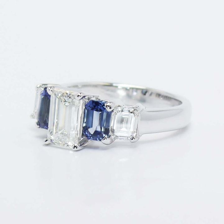 three stone ring with blue and white stones on the sides, set in 18k white gold