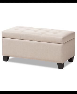 a beige bench with black legs and a buttoned up seat on the backrest