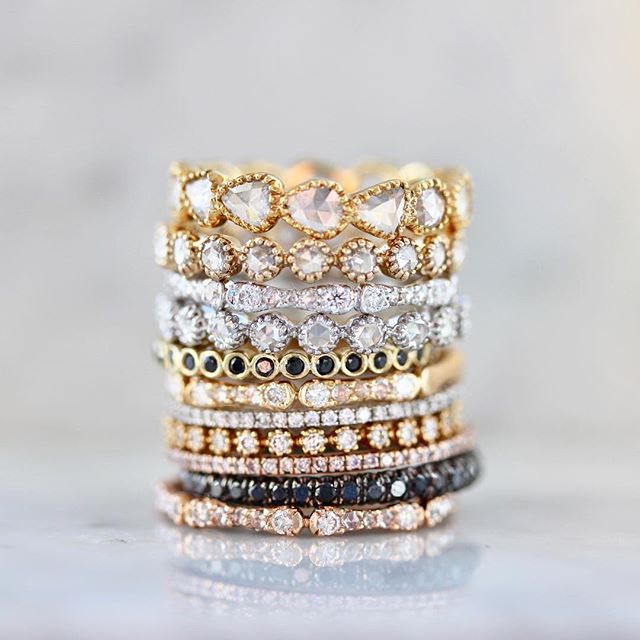 stacking rings with different colored stones on top of each other in gold, silver and black