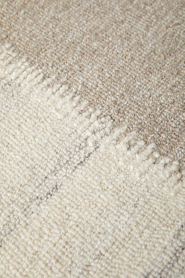 closeup of the texture of a rug with white and beige colors on it,