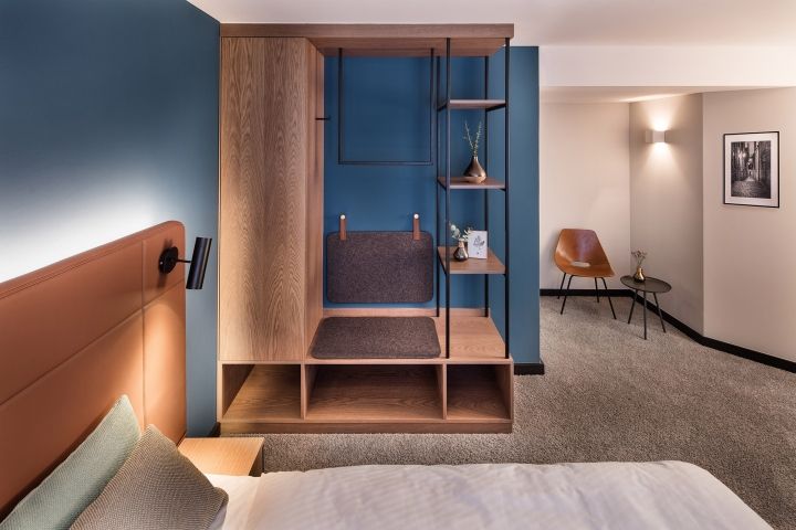 a bed room with a neatly made bed and a book shelf next to the bed