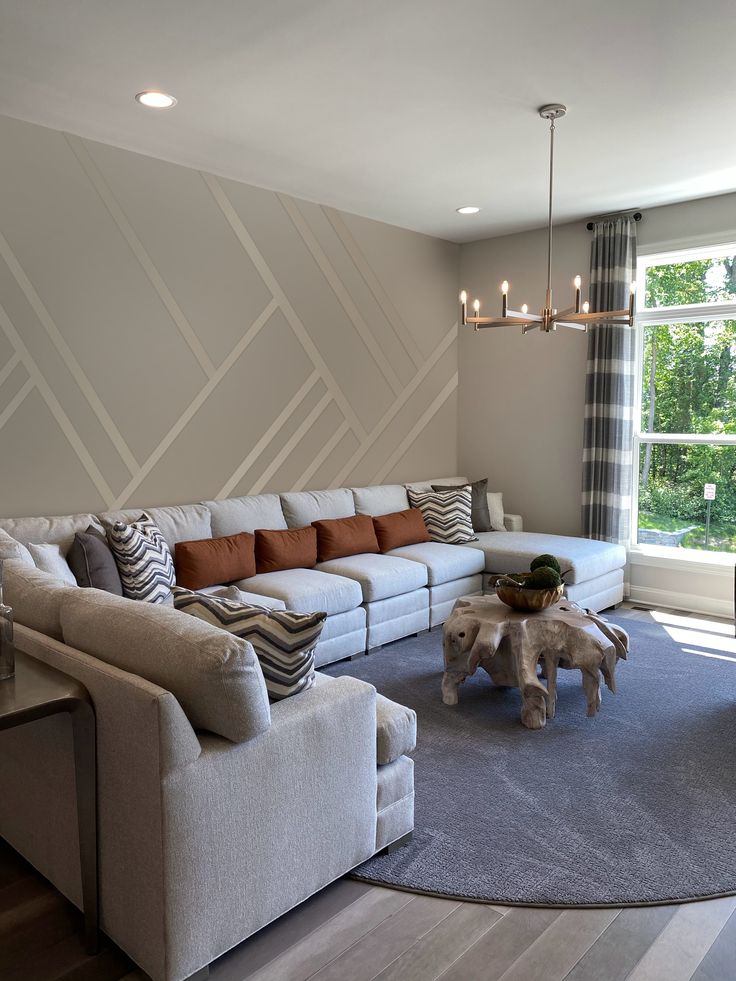 a living room filled with furniture next to a large window and a rug on the floor