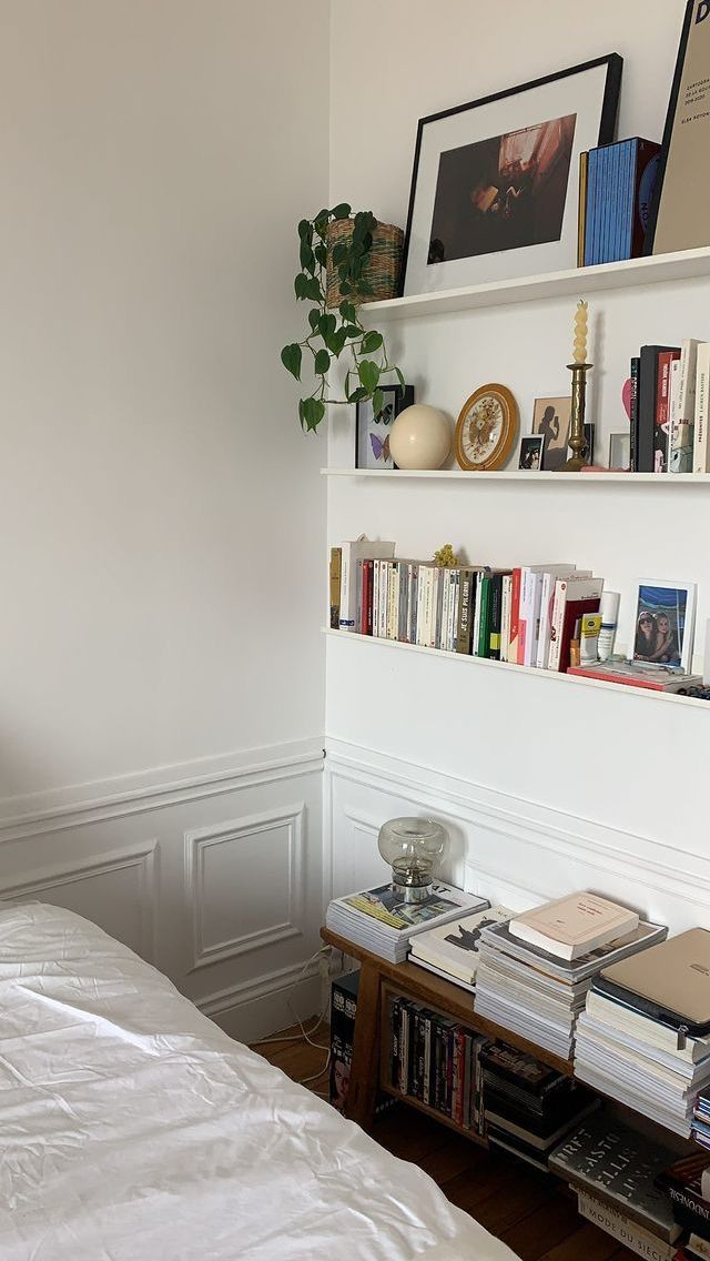 a bedroom with white walls and bookshelves on the wall