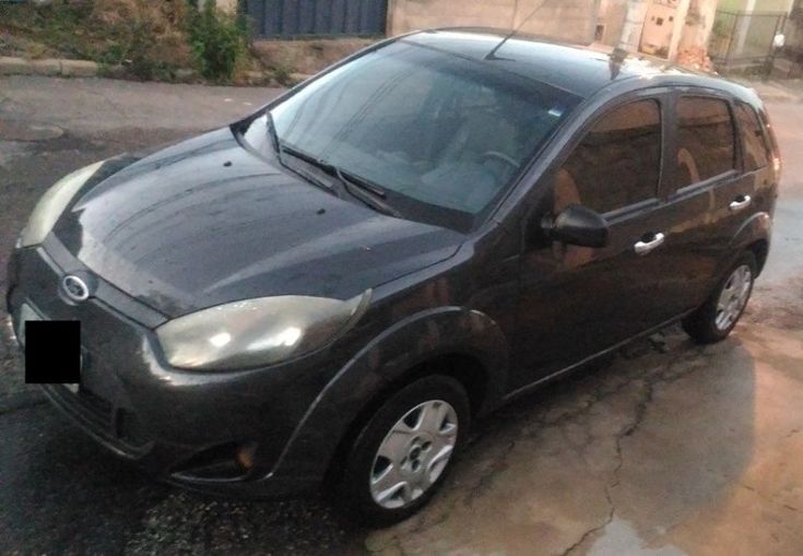 a small black car parked on the street