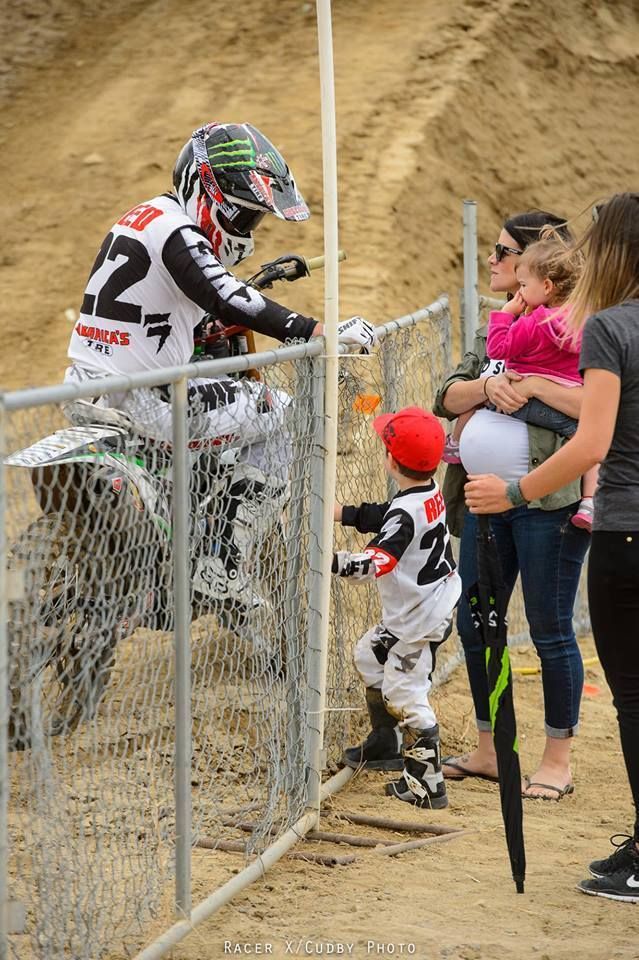 a group of people standing next to each other near a fence