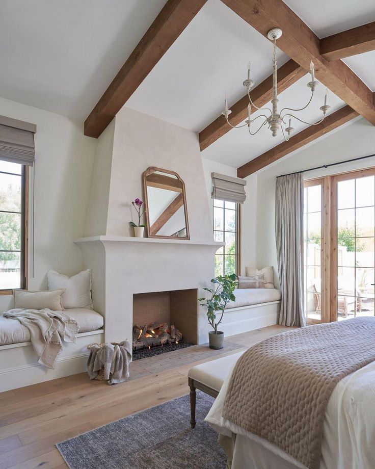 a bedroom with a fireplace, bed and windows