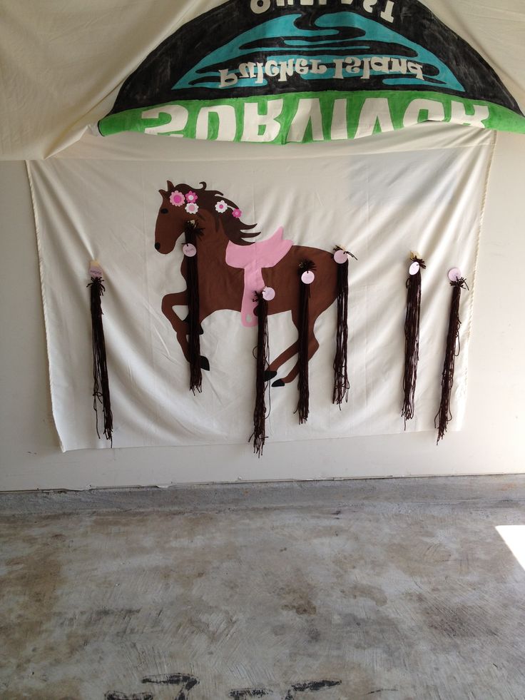 there is a sign with horses on it and fringes hanging from the wall behind it