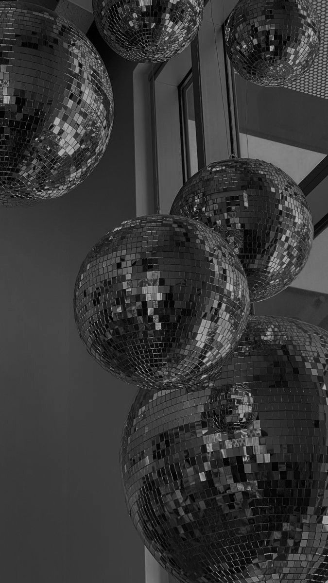 black and white photograph of disco balls hanging from the ceiling