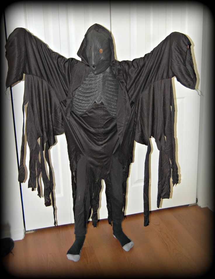 a person in a black costume standing on a wooden floor