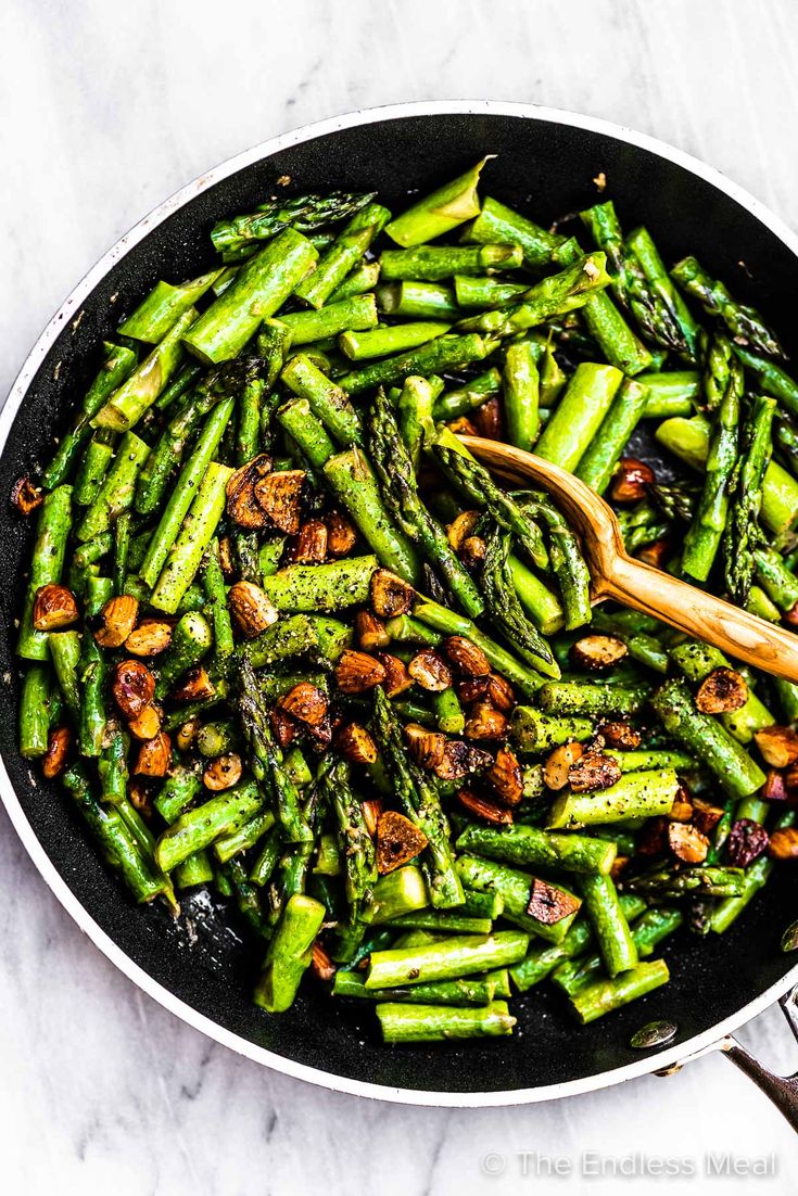 asparagus and almonds cooking in a skillet