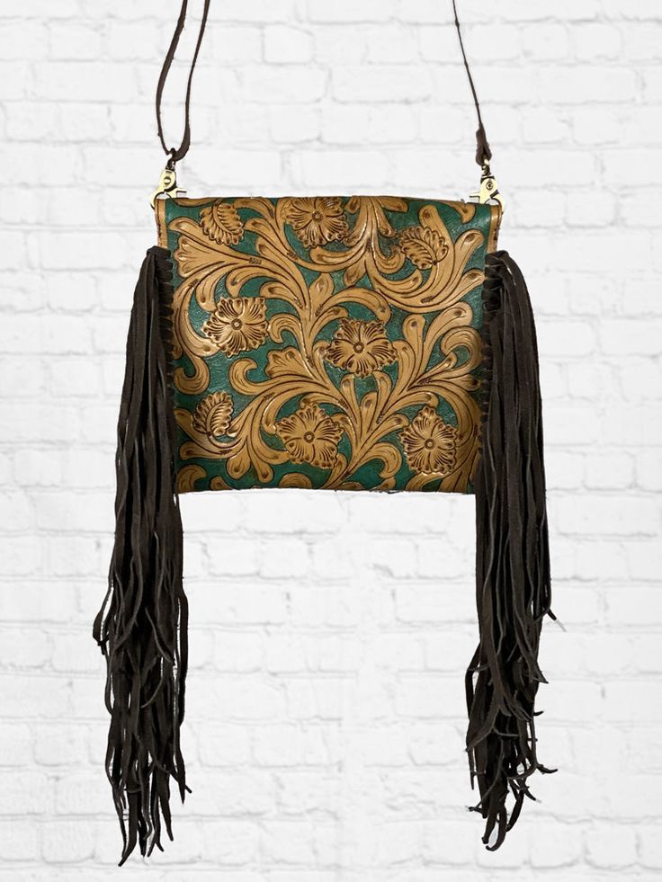 This rustic western handbag is a tooled leather dream! Crafted with intricate hand-tooled leather and adorned with long fringe, this handbag is the perfect accessory to complete your western look. Made with high-quality leather, it's not only beautiful but also durable. Closure Type Flap Size 11.5"w x 9"h x 1"d Strap Type Narrow, leather, adjustable crossbody strap Western Brown Bag With Fringe, Brown Western Bag With Fringe, Western Leather Bag With Fringe, Western Style Bags With Fringe For Everyday Use, Western Style Fringe Bags For Everyday Use, Western Style Fringed Bags For Everyday Use, Western Handbag, Tooled Leather Handbags, Western Handbags