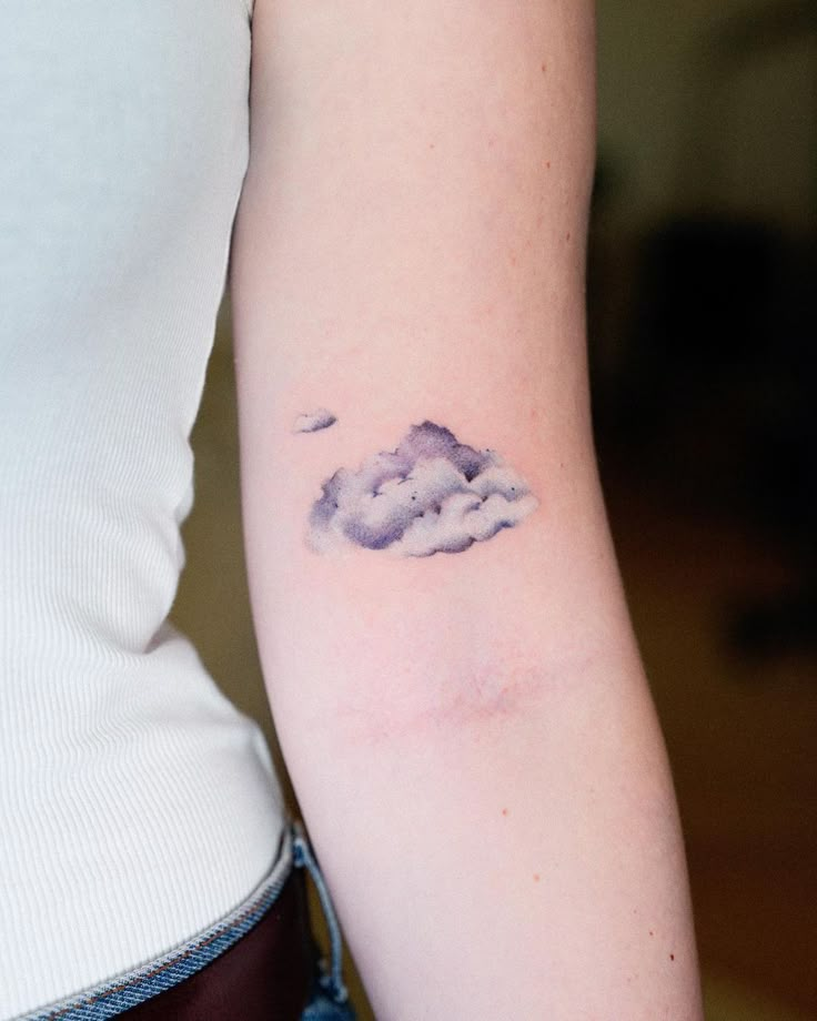 a woman with a cloud tattoo on her arm