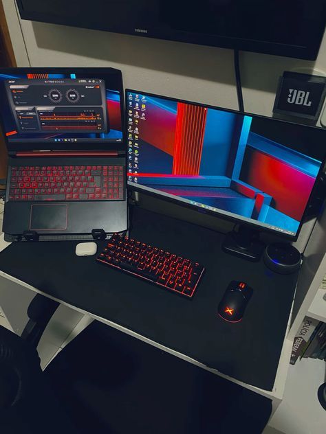 a desk with two laptops and a desktop computer on it, all in different colors