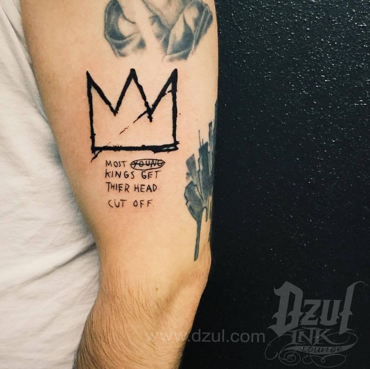 a man with a crown tattoo on his arm