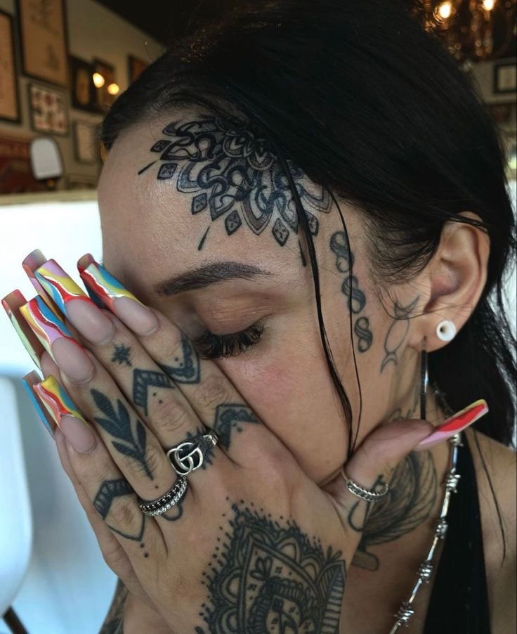 a woman with tattoos covering her face and hands