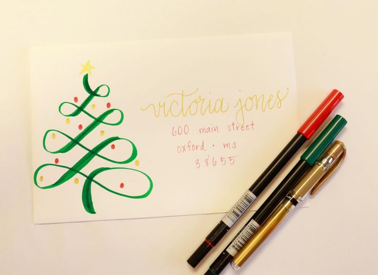 three pens are sitting next to a christmas tree greeting card and two other holiday cards