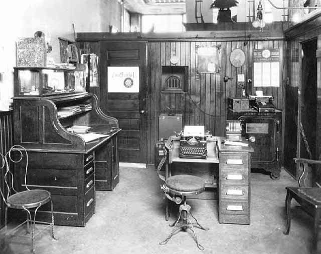 an old fashioned office with many desks and chairs