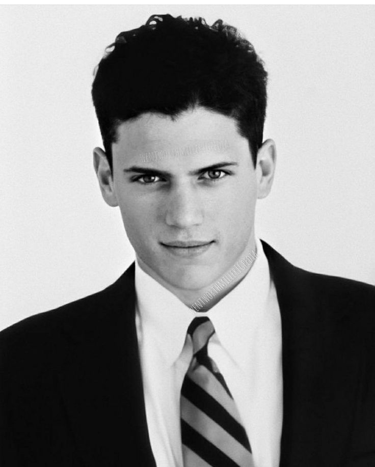 a black and white photo of a man in a suit with a striped neck tie