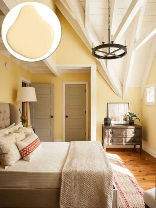 a bedroom with yellow walls and white beams on the ceiling is decorated in neutral colors