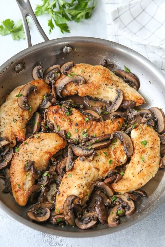 chicken with mushrooms and parsley in a skillet