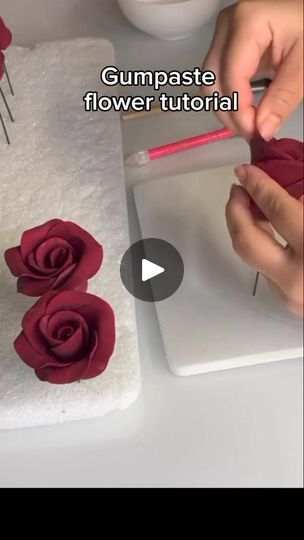 someone is decorating a cake with red roses on it and the words gumpaste flower tutor