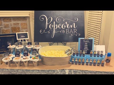 a buffet table with popcorn and drinks on it, next to a sign that says popcorn bar