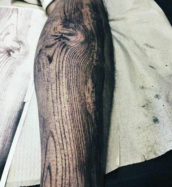 a close up of a person's leg with wood on it