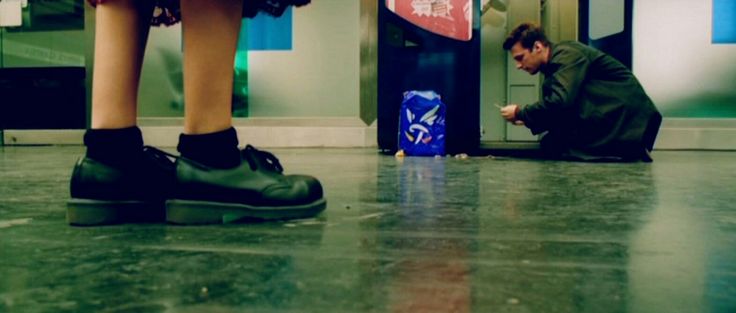 a man sitting on the ground next to a woman in front of a atm machine