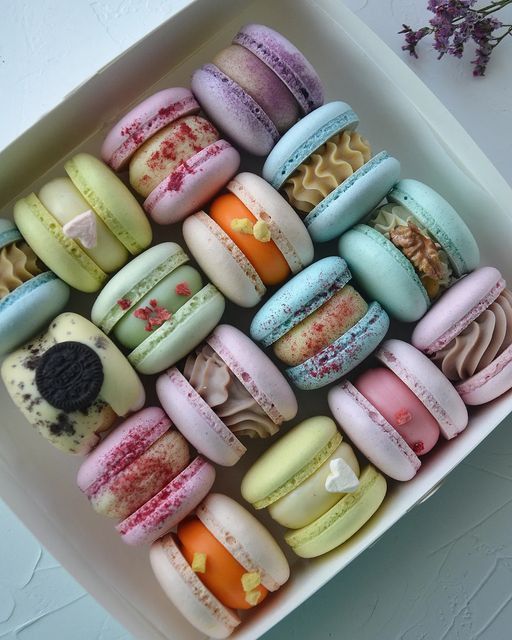 a box filled with lots of different flavored macaroons