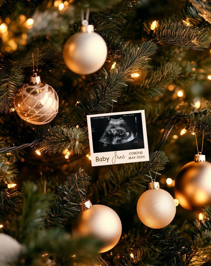 a baby's first christmas ornament is hanging on the top of a christmas tree