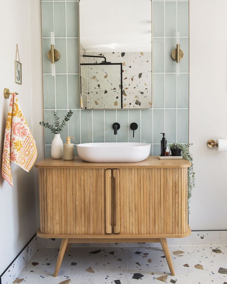 a bathroom with a sink, mirror and wooden cabinet