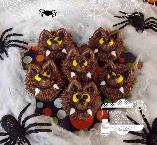 chocolate cupcakes decorated with spider's and eyes on top of white fluffy material