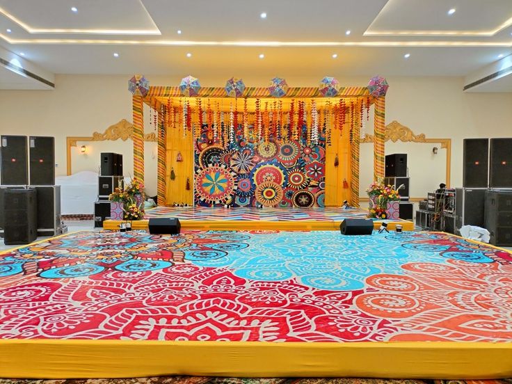 an elaborately decorated stage set up for a wedding or other special event with bright colors