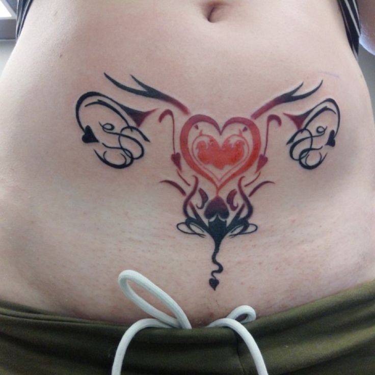 a woman's stomach with tattoos on it, including an elephant and heart tattoo