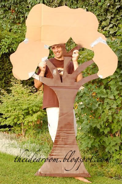 a man standing in front of a cardboard tree