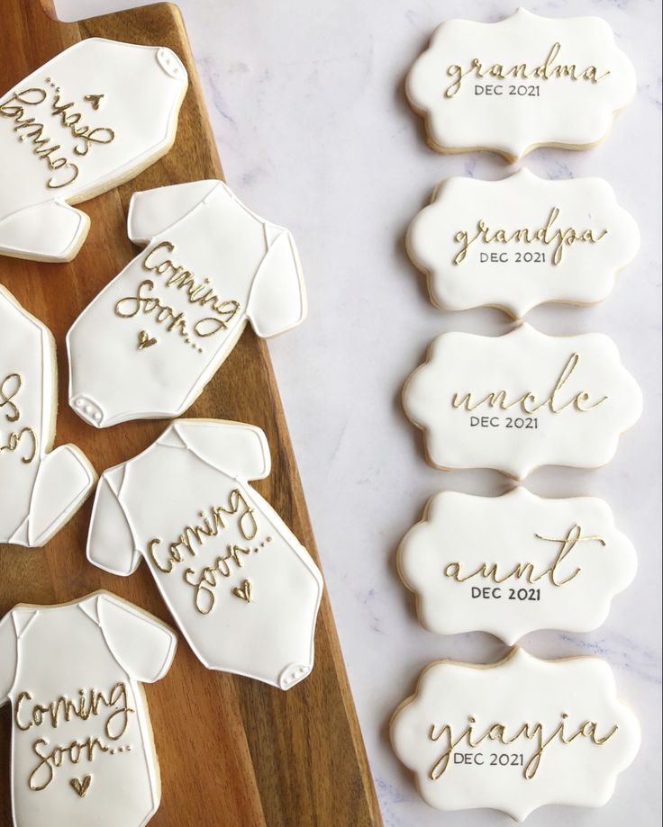 decorated cookies with names on them sitting on a cutting board next to other cookie decorations