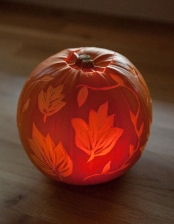 an orange painted pumpkin sitting on top of a wooden floor next to a window sill