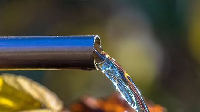 a close up of a blue pipe pouring water