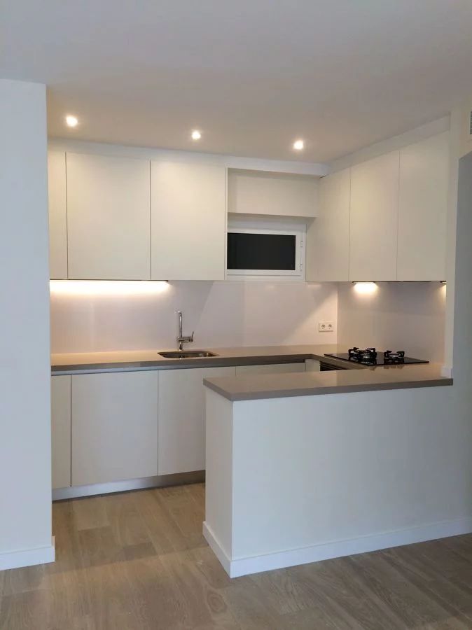 an empty kitchen with white cabinets and counter tops