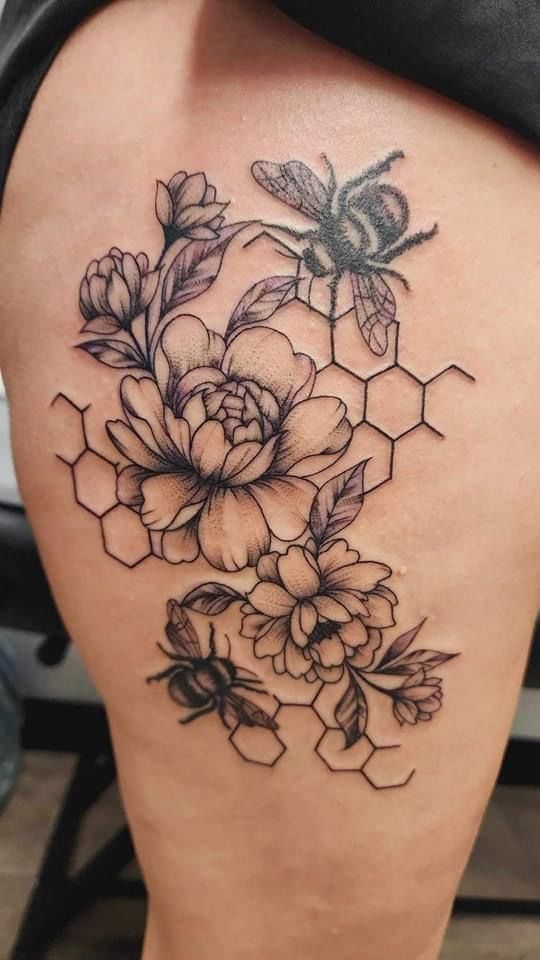 the back of a woman's thigh with flowers and honeycombs on it