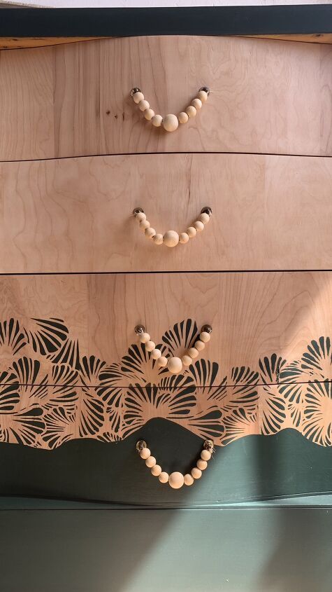 a wooden dresser with beads on the drawers