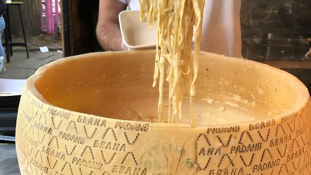 a person pouring noodles into a large bowl