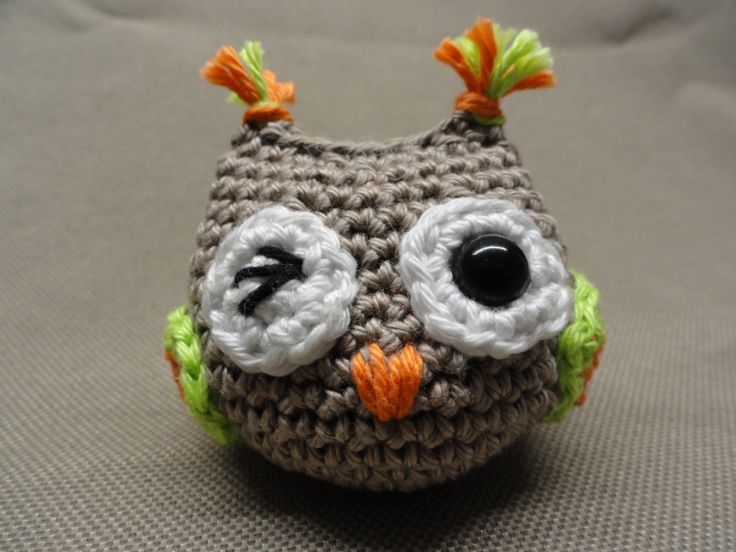 a crocheted owl sitting on top of a bed