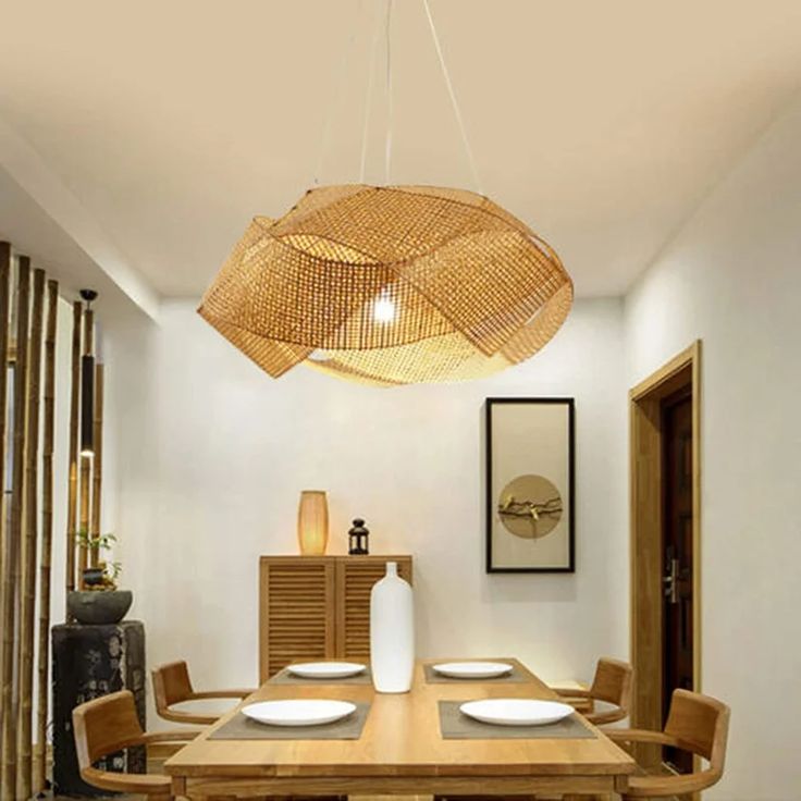 a dining room table with chairs and a large bamboo light fixture hanging over it's head