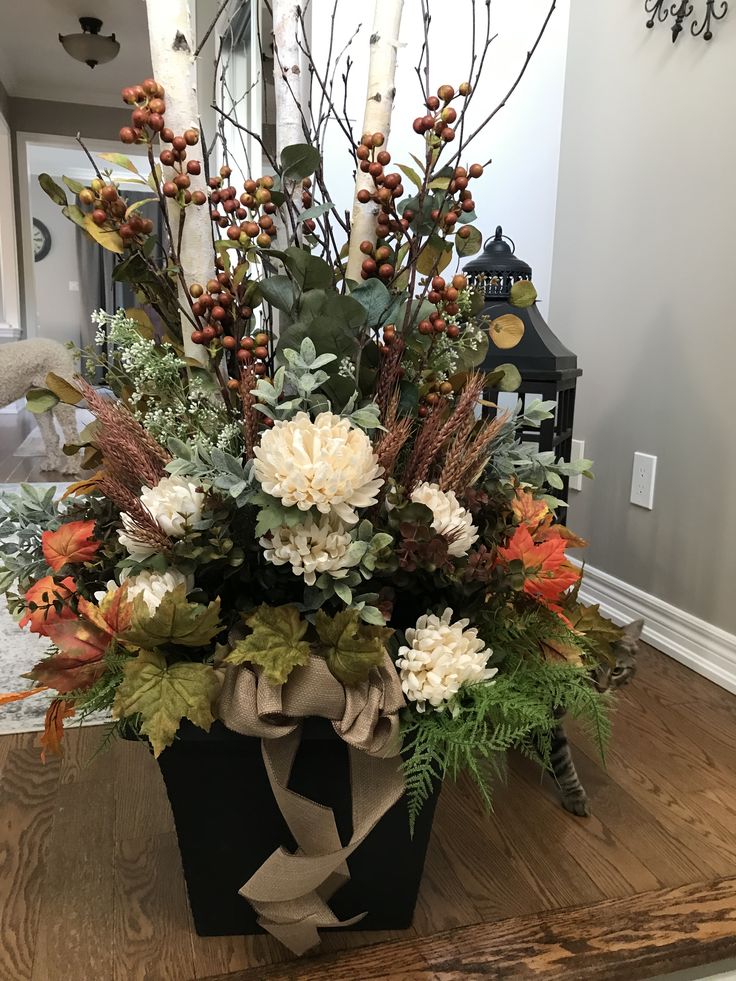 a vase filled with flowers on top of a wooden table