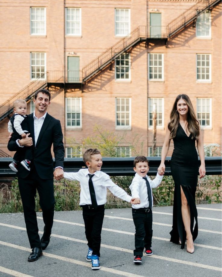 a man and woman holding hands with two children