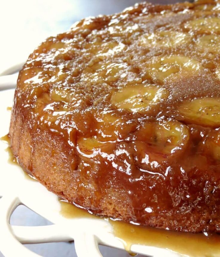 a banana upside down cake sitting on top of a white plate with caramel sauce