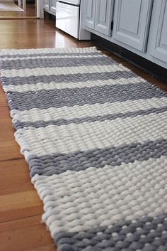 a gray and white rug on the floor in a kitchen