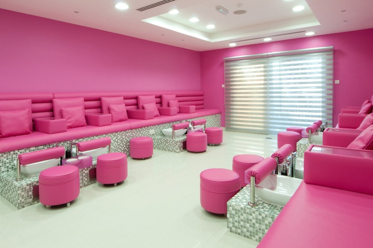 a room with pink couches and stools in it